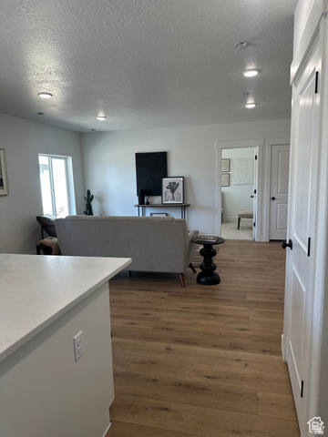 7927 Bristlecone Road, Unit 204 Eagle Mountain, UT 84005 - Photo 16 of 19 Living area with dark wood-style flooring and a textured ceiling