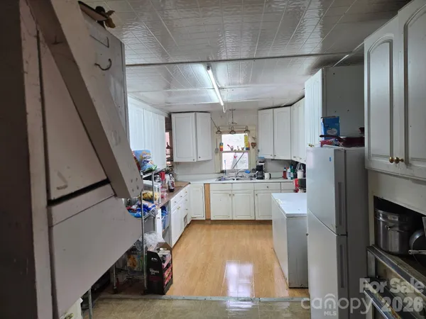 a view of kitchen with furniture and refrigerator