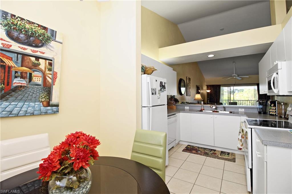 422 Valerie Way, Unit 202 Naples, FL 34104 - Photo 2 of 19 a kitchen with stainless steel appliances kitchen island granite countertop a sink and cabinets
