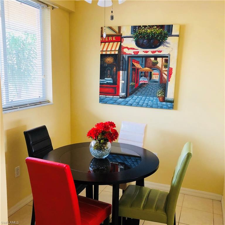 422 Valerie Way, Unit 202 Naples, FL 34104 - Photo 3 of 19 a view of a dining room with furniture and wooden floor