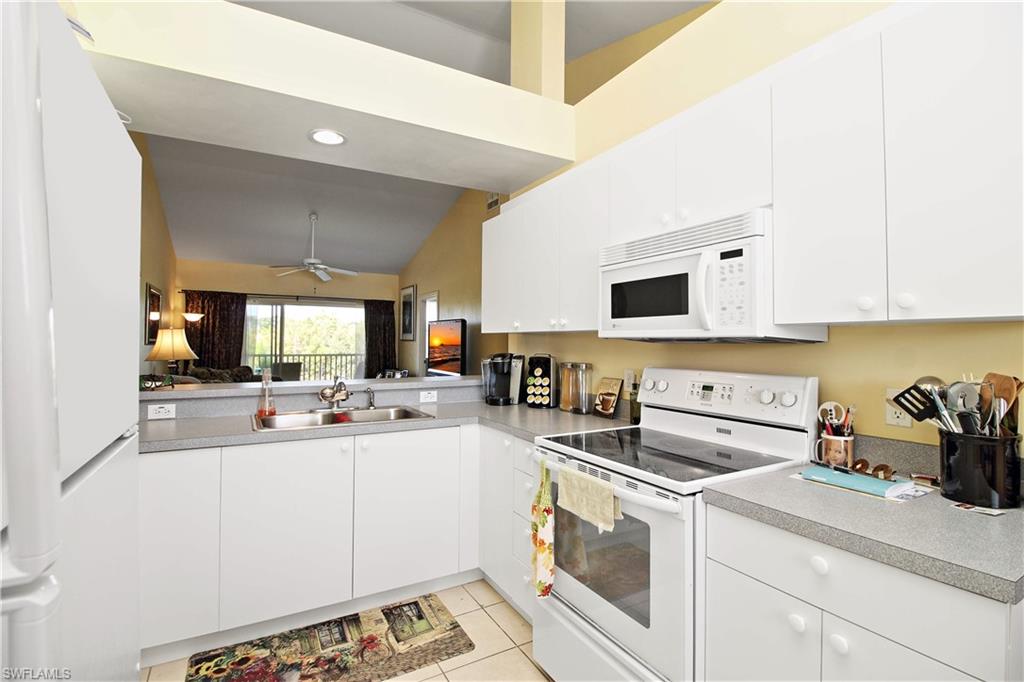 422 Valerie Way, Unit 202 Naples, FL 34104 - Photo 4 of 19 a kitchen with a sink a stove and cabinets