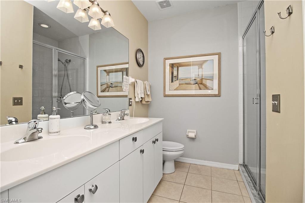 422 Valerie Way, Unit 202 Naples, FL 34104 - Photo 8 of 19 a spacious bathroom with a toilet sink and mirror