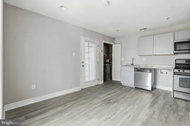 a view of kitchen with stainless steel appliances refrigerator and stove top oven