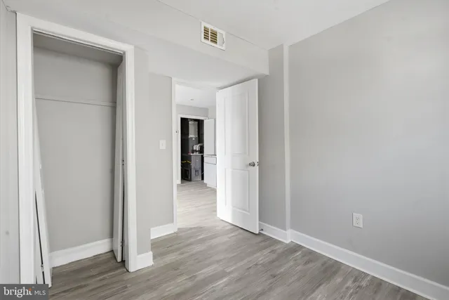 a view of an empty room with wooden floor