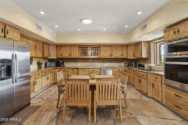 a kitchen with stainless steel appliances granite countertop a stove a sink a microwave a refrigerator and cabinets