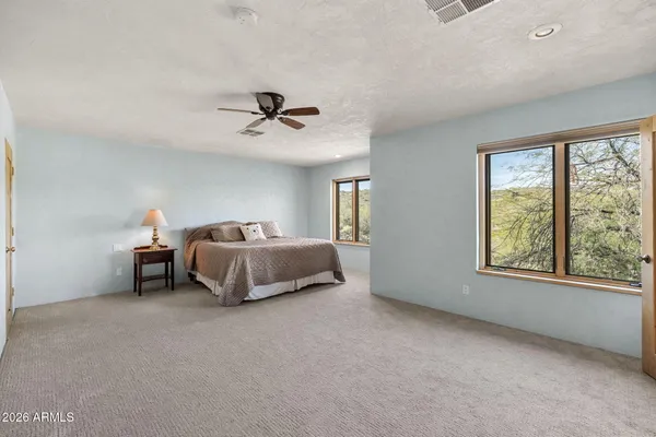 a spacious bedroom with a bed and a window