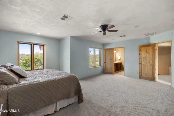 a spacious bedroom with a bed and a chandelier
