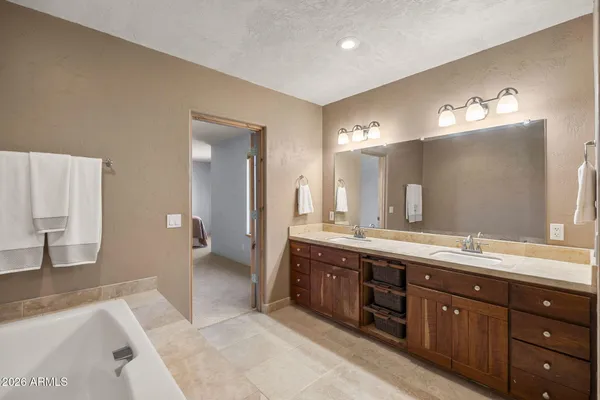 a spacious bathroom with a tub double sink and mirror