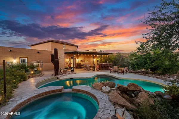 a view of a swimming pool with lawn chairs and a fire pit