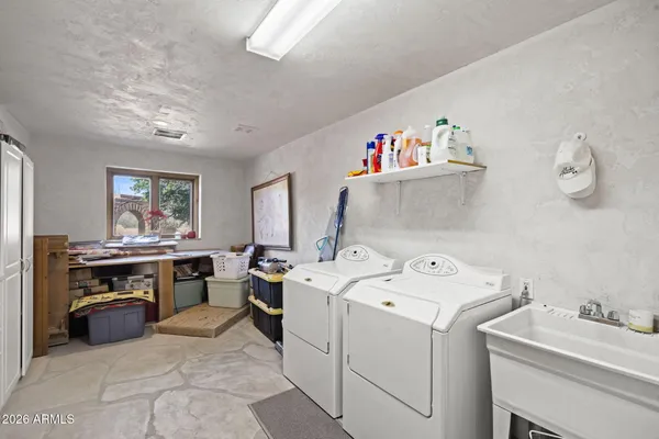 a utility room with dryer washer and a view of living room