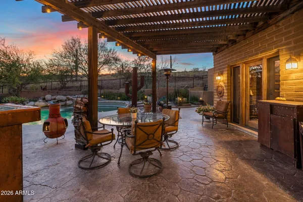 a view of a patio with table and chairs next to a yard