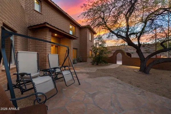a view of backyard with a table and chairs and a large tree