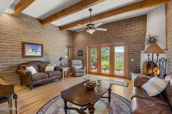 a living room with furniture a rug and a floor to ceiling window