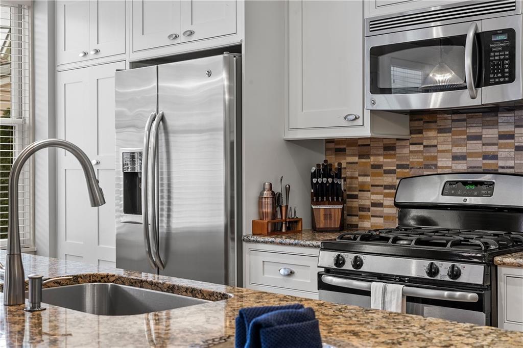 706 Ivy Street, Unit 2 Pittsburgh, PA 15232 - Photo 15 of 35 a kitchen with stainless steel appliances granite countertop a stove a microwave and a refrigerator