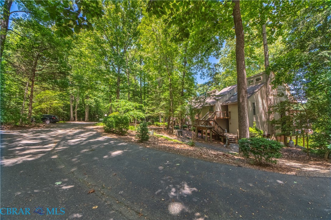 54 Villa Ridge Drive, Unit C Hartfield, VA 23071 - Photo 7 of 45 View of yard featuring a wooden deck and asphalt driveway