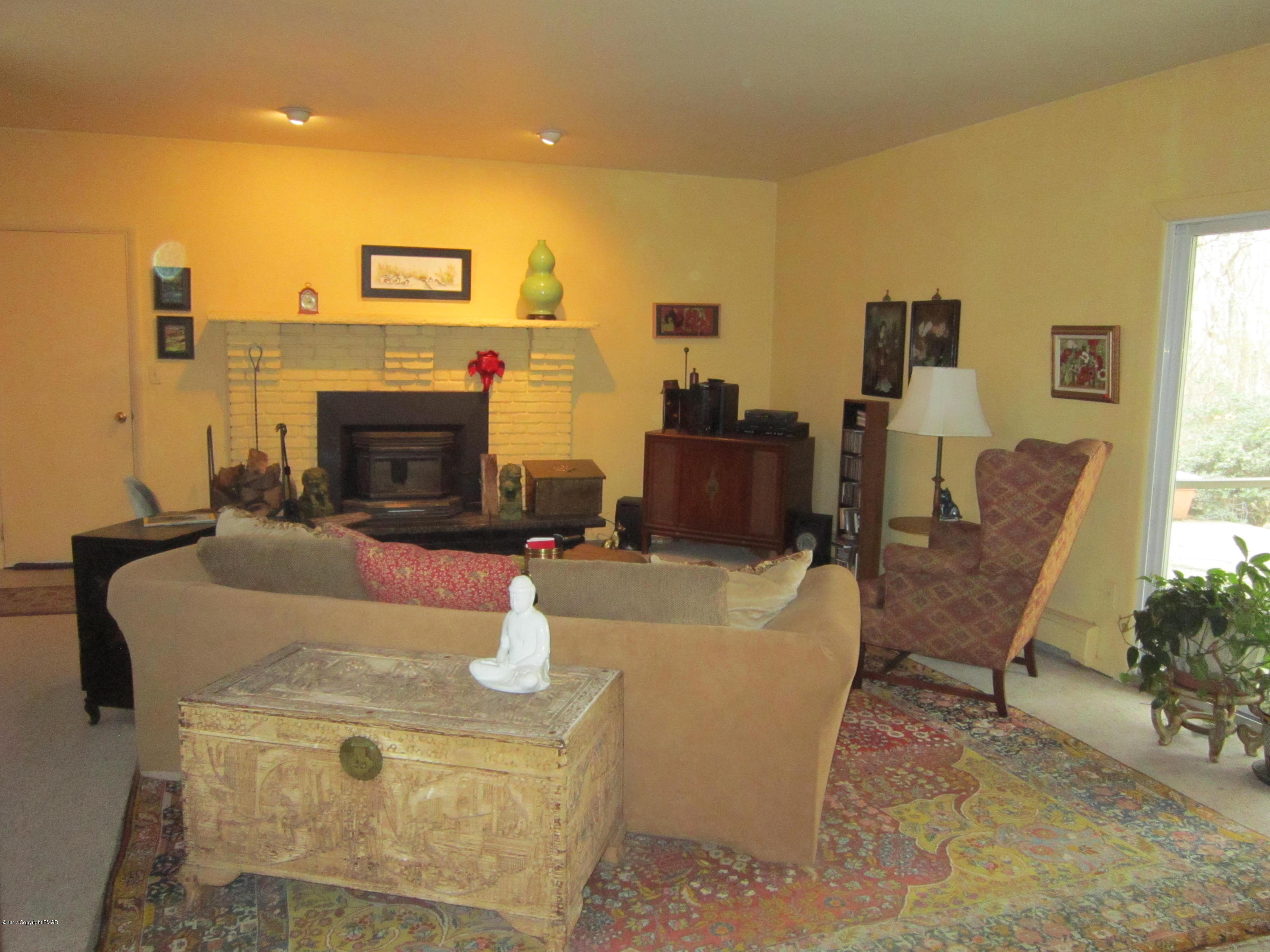 319 Henry's Crossing Road Cresco, PA 18326 - Photo 6 of 29 a living room with furniture a fireplace and a potted plant
