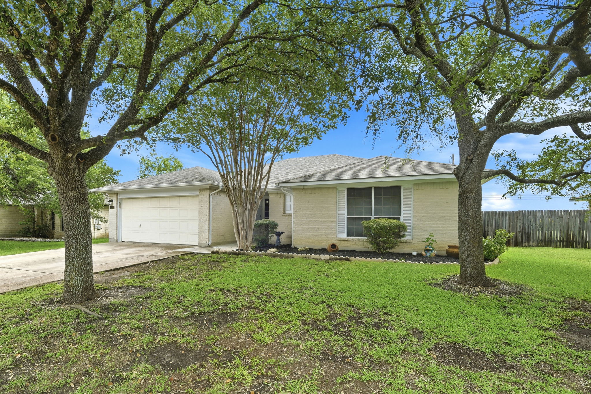 A classic brick exterior and well-maintained lawn frame this inviting single-story residence.