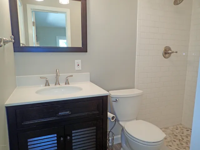 a bathroom with a sink a toilet and mirror