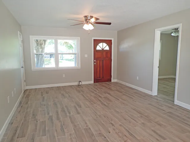 wooden floor in an empty room with a window