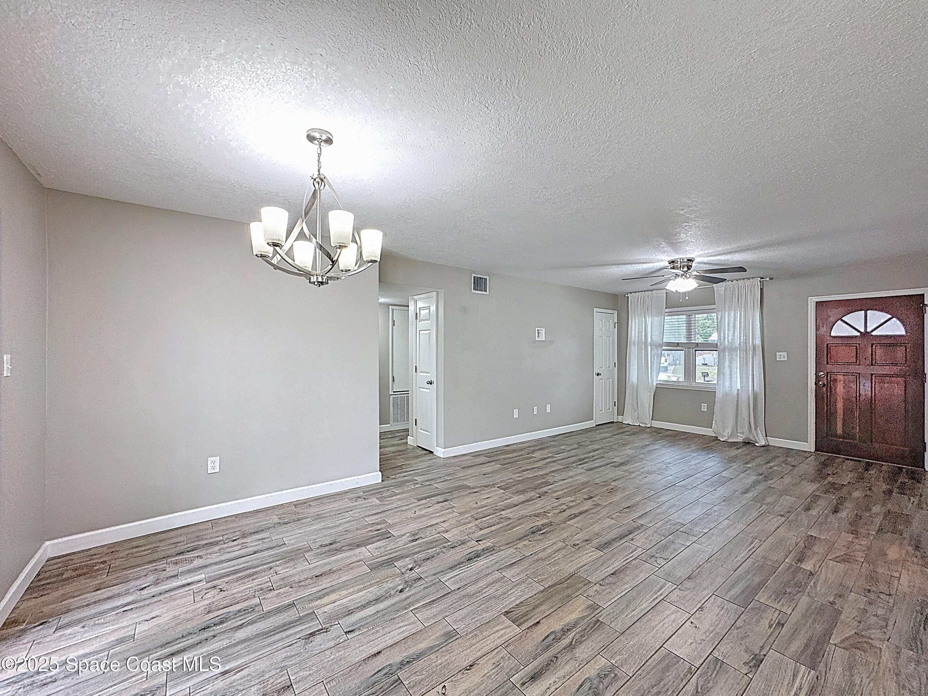 170 Moore Avenue Merritt Island, FL 32952 - Photo 14 of 23 a view of an empty room with window and wooden floor