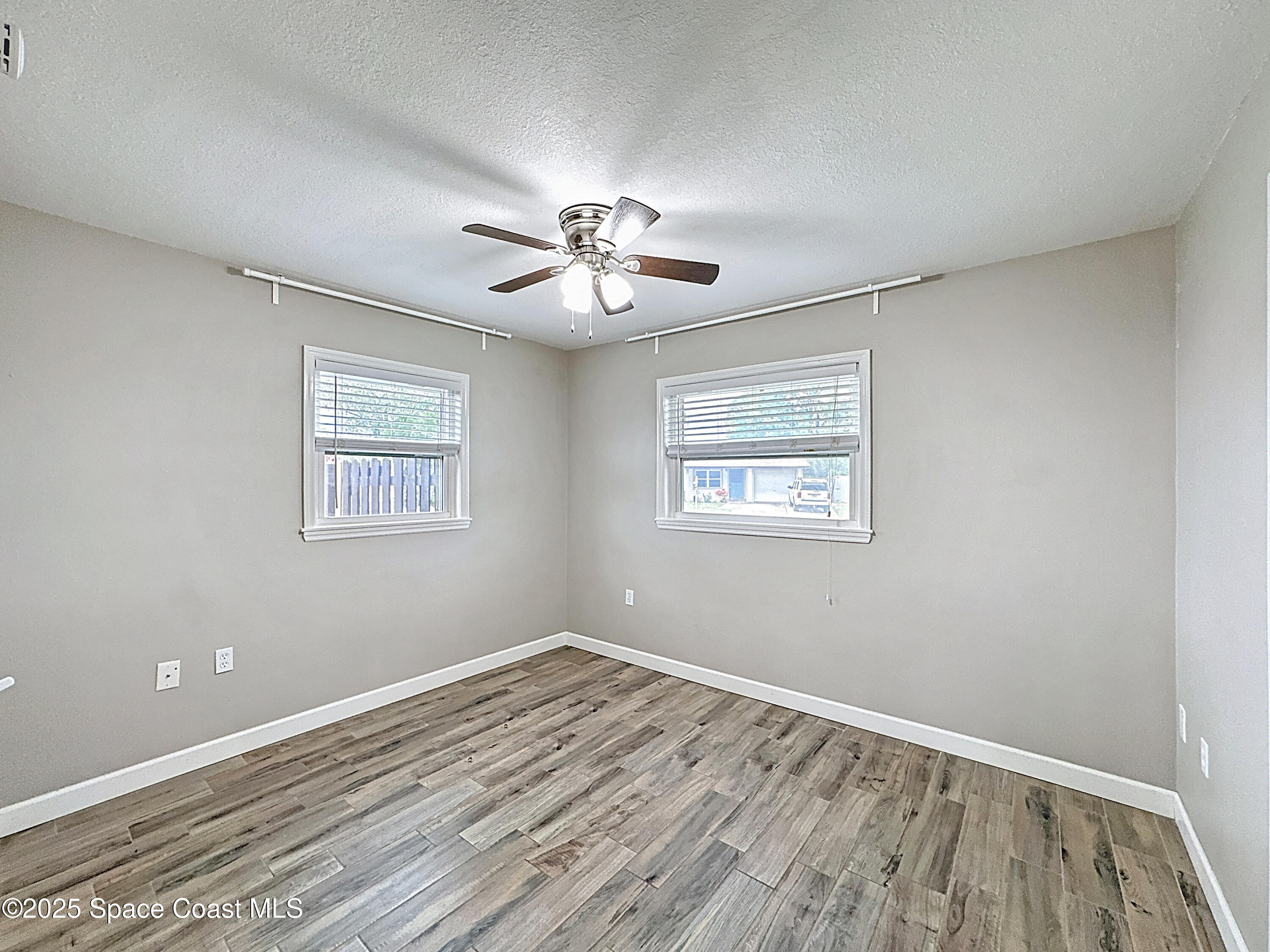 170 Moore Avenue Merritt Island, FL 32952 - Photo 16 of 23 a view of a room with wooden floor and a ceiling fan