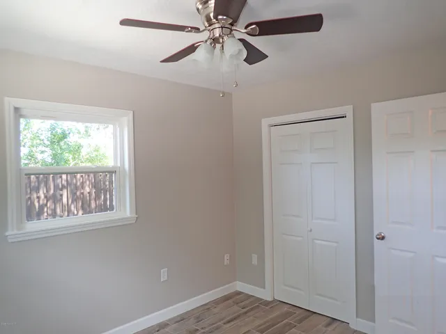 a view of empty room with window and wooden floor