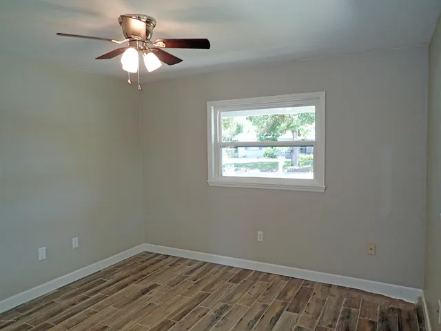 an empty room with a window and a fan