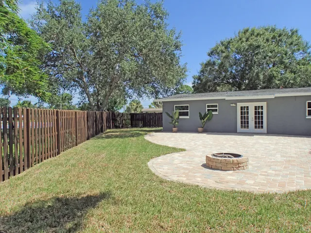 a view of a house with backyard and trees