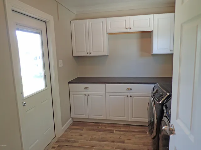 a kitchen with white cabinets and white appliances