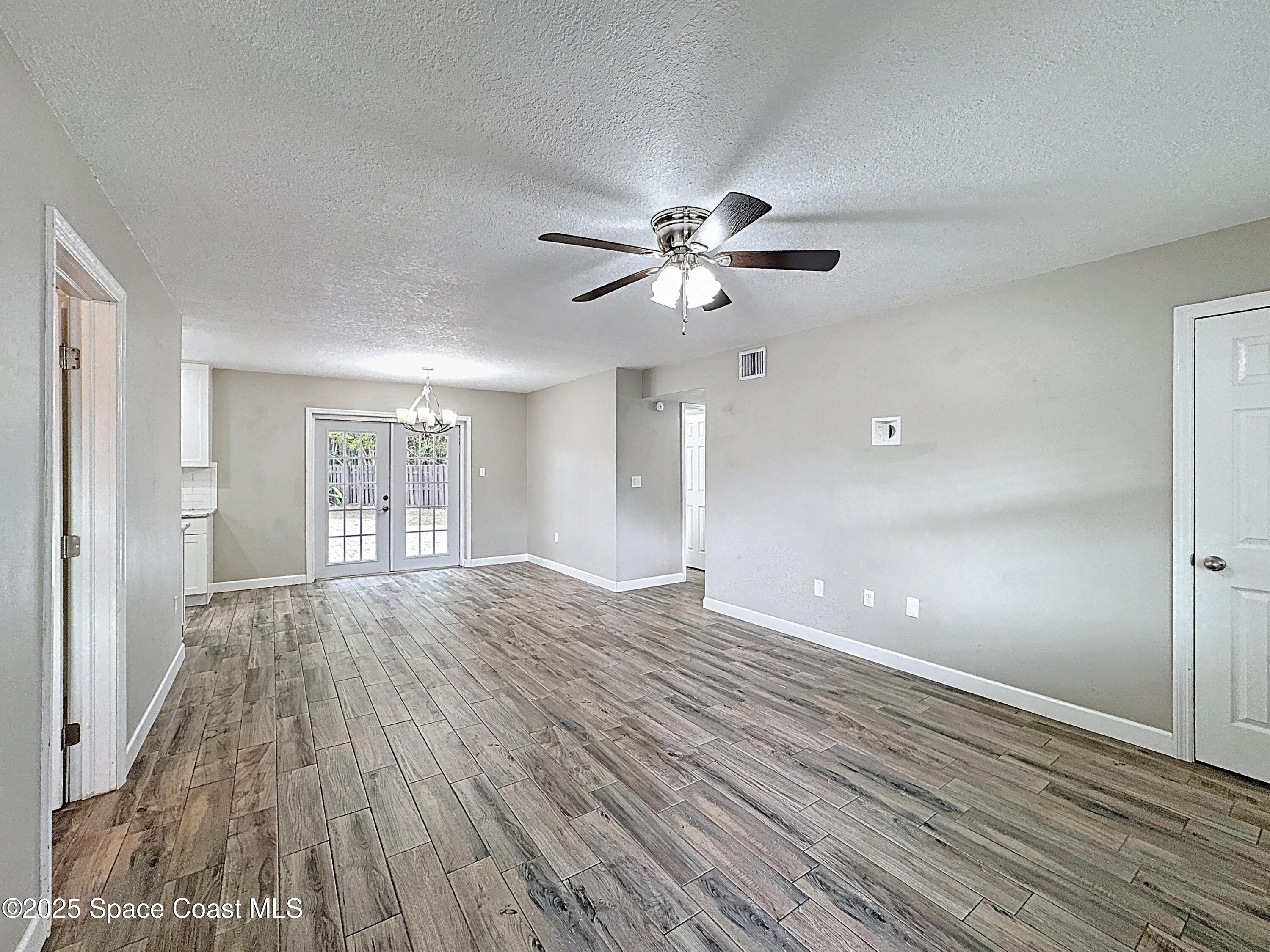 170 Moore Avenue Merritt Island, FL 32952 - Photo 3 of 23 a view of an empty room with a window and wooden floor
