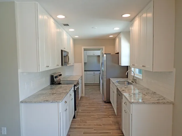 a kitchen with a sink stove top oven and refrigerator