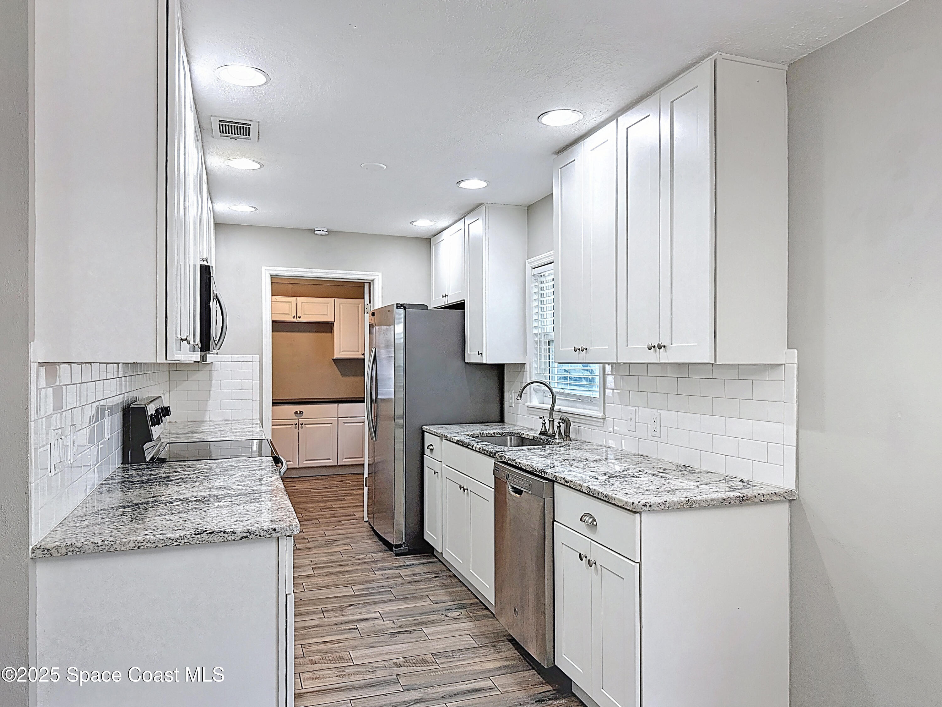 170 Moore Avenue Merritt Island, FL 32952 - Photo 8 of 23 a kitchen with a sink stove and refrigerator