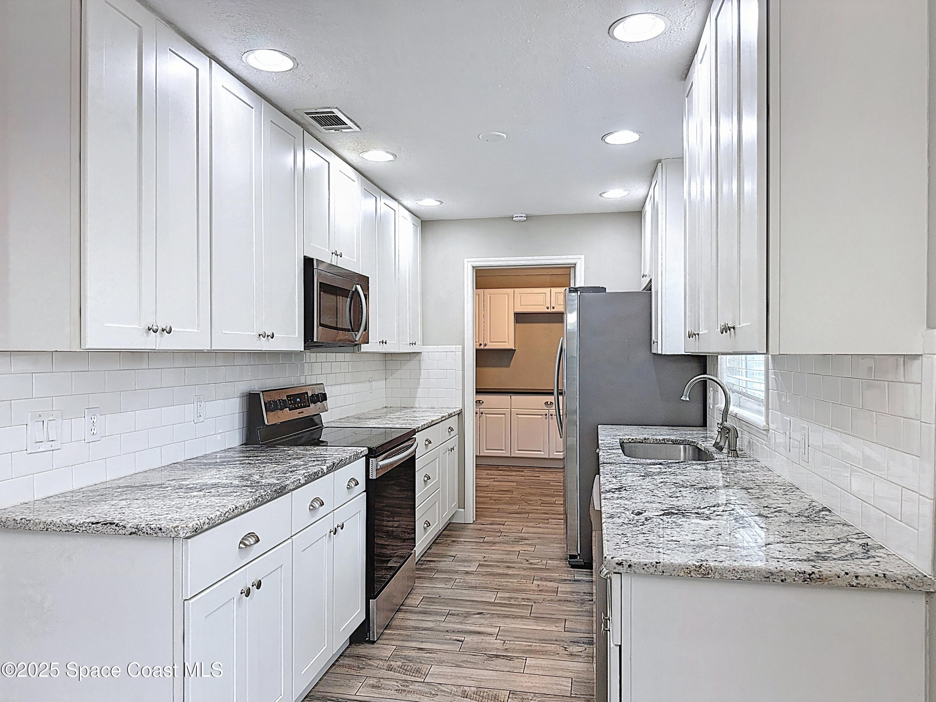 170 Moore Avenue Merritt Island, FL 32952 - Photo 9 of 23 a kitchen with stainless steel appliances granite countertop a sink stove and refrigerator