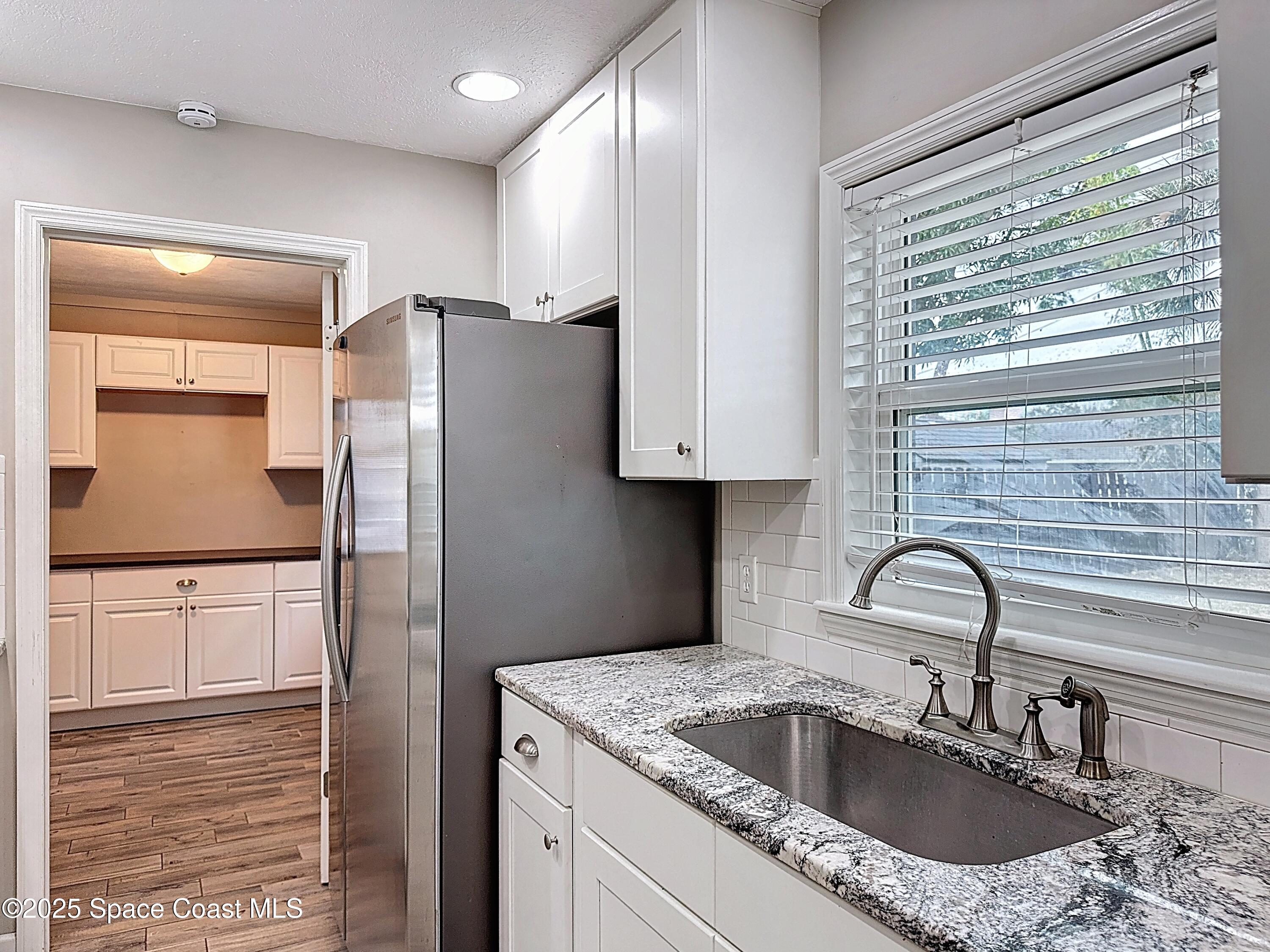 170 Moore Avenue Merritt Island, FL 32952 - Photo 10 of 23 a kitchen with granite countertop a sink stainless steel appliances and cabinets
