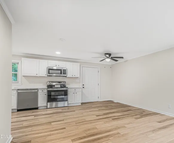 a view of kitchen with wooden floor and electronic appliances