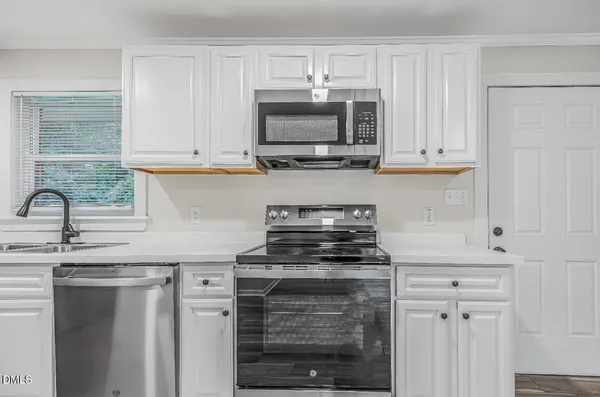 a kitchen with stainless steel appliances granite countertop a stove and a microwave