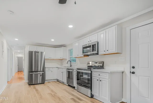 a kitchen with stainless steel appliances granite countertop a refrigerator and a stove top oven