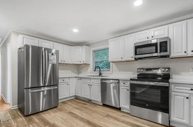 a kitchen with granite countertop a refrigerator stove and microwave