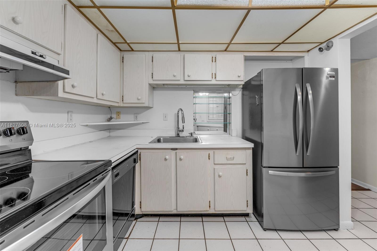 9159 Southwest 77th Avenue, Unit 314 Miami, FL 33156 - Photo 6 of 22 a kitchen with stainless steel appliances a refrigerator sink and cabinets