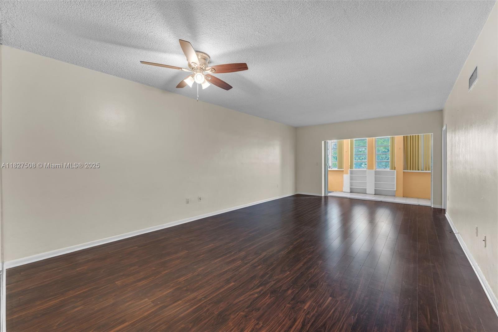 9159 Southwest 77th Avenue, Unit 314 Miami, FL 33156 - Photo 8 of 22 an empty room with wooden floor fan and windows