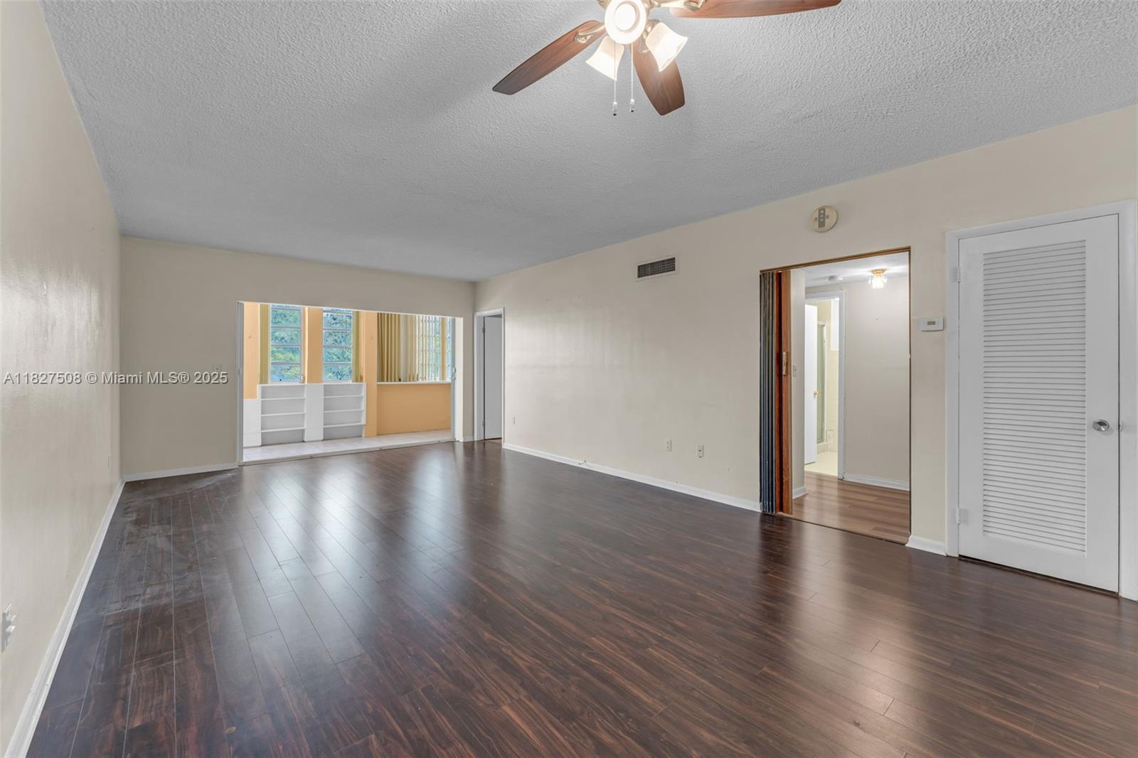9159 Southwest 77th Avenue, Unit 314 Miami, FL 33156 - Photo 9 of 22 a view of an empty room with wooden floor and a window