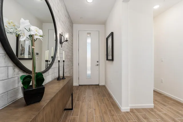 a view of a hallway with wooden floor and stairs