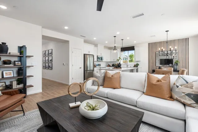 a living room with furniture kitchen view and a table