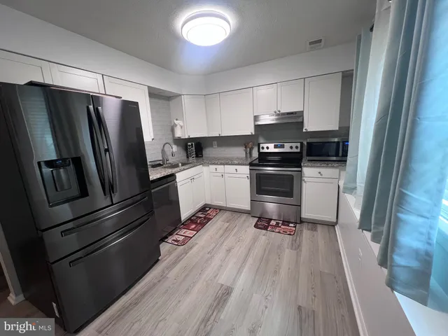 a kitchen with granite countertop a refrigerator and a sink