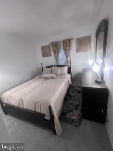 a large bed sitting in a room next to a lamp