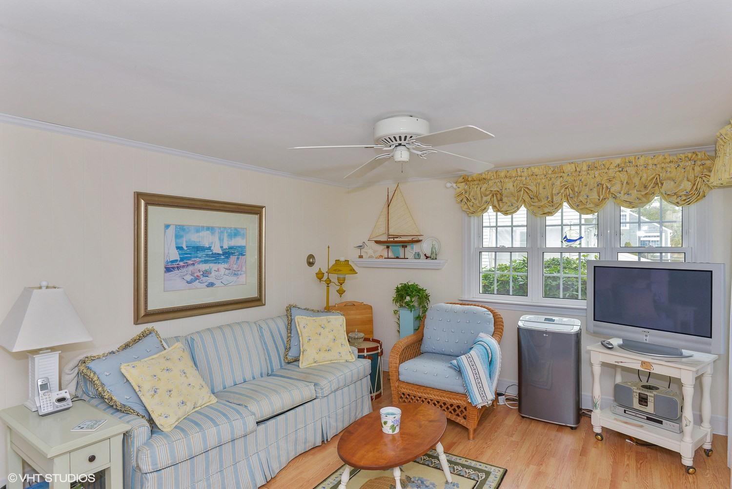 43 Uncle Rolf Road Dennis Port, MA 02639 - Photo 3 of 15 a living room with furniture a flat screen tv and a floor to ceiling window