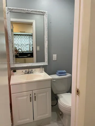 a view of bathroom with a toilet sink and mirror