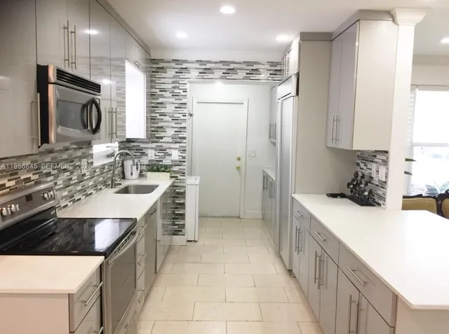 a kitchen with a sink stove and refrigerator