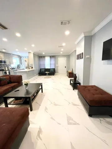 a living room with stainless steel appliances kitchen island furniture and a kitchen view