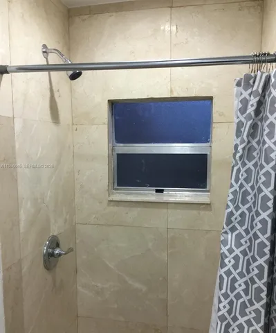 a kitchen with granite countertop a refrigerator a stove and wooden cabinets